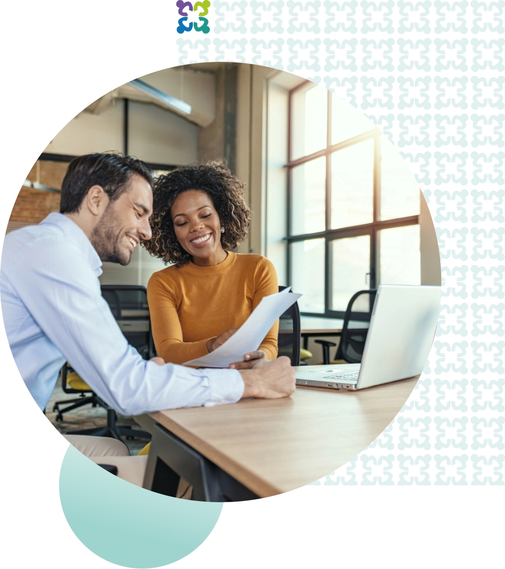 woman and man smiling as they review documents