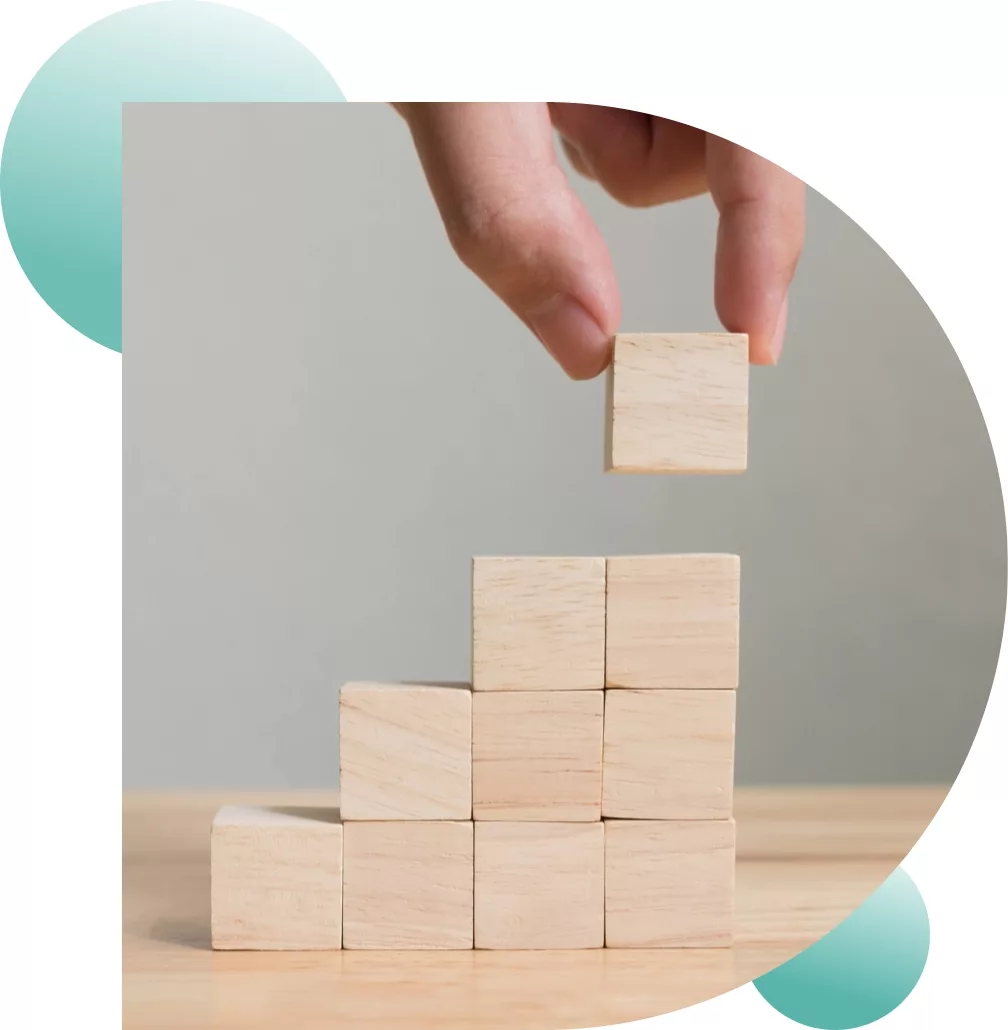 close up of a hand arranging ten wooden blocks to form a triangle staircase